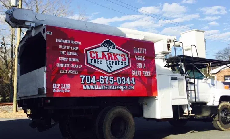 A clark 's tree express truck is parked on the side of the road