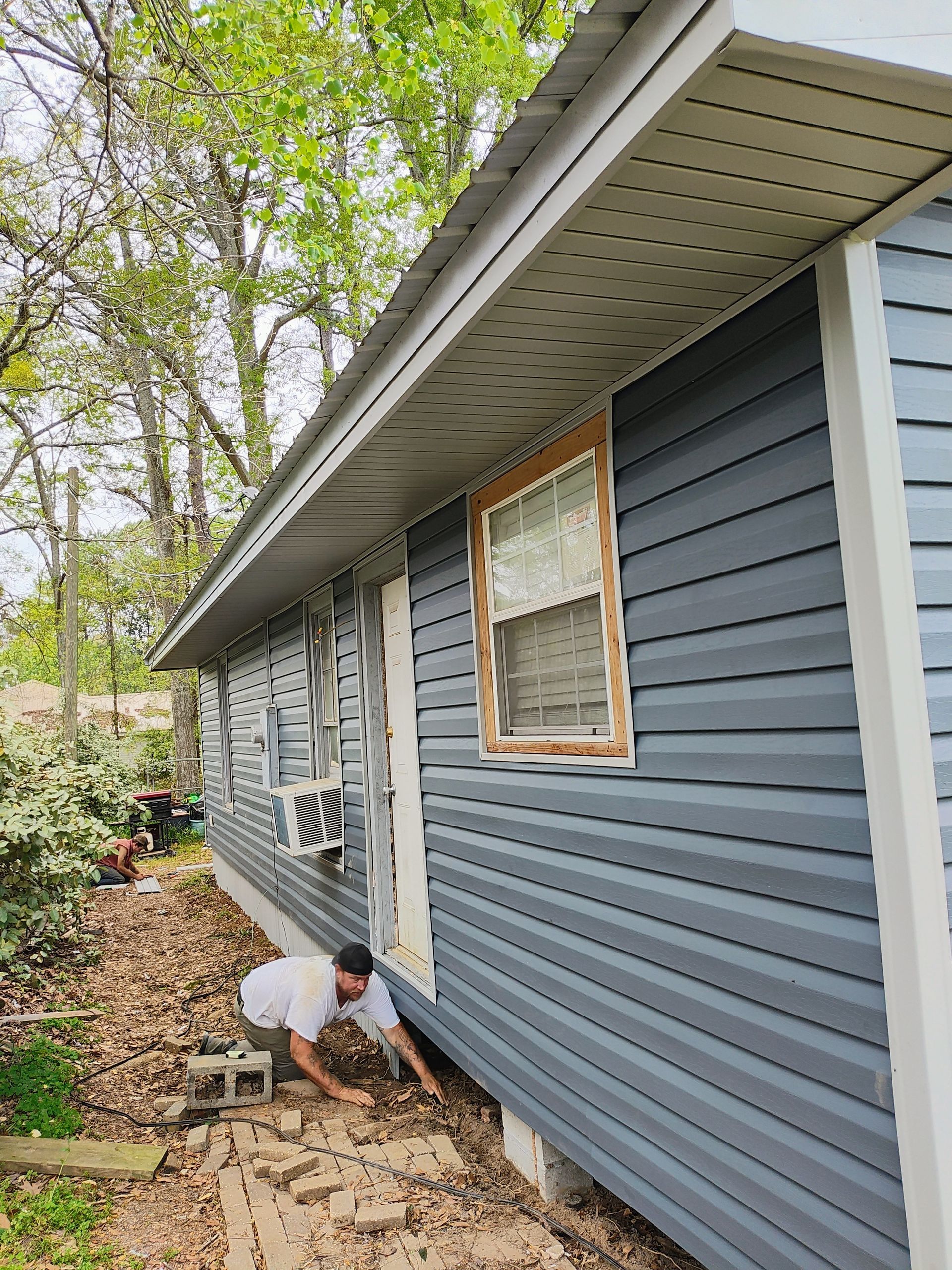 A man is working on the side of a house.