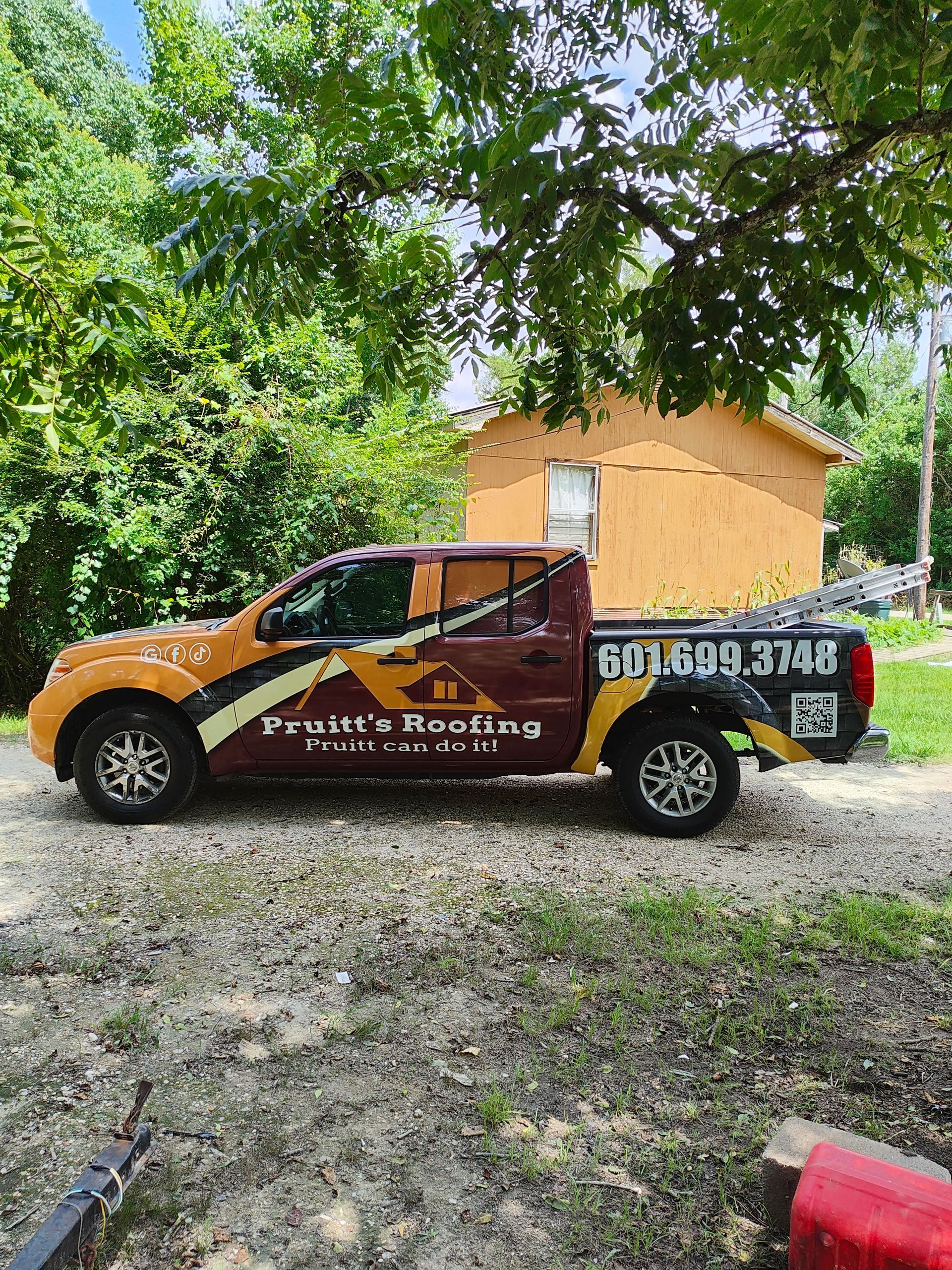 A roofing truck is parked in front of a house.