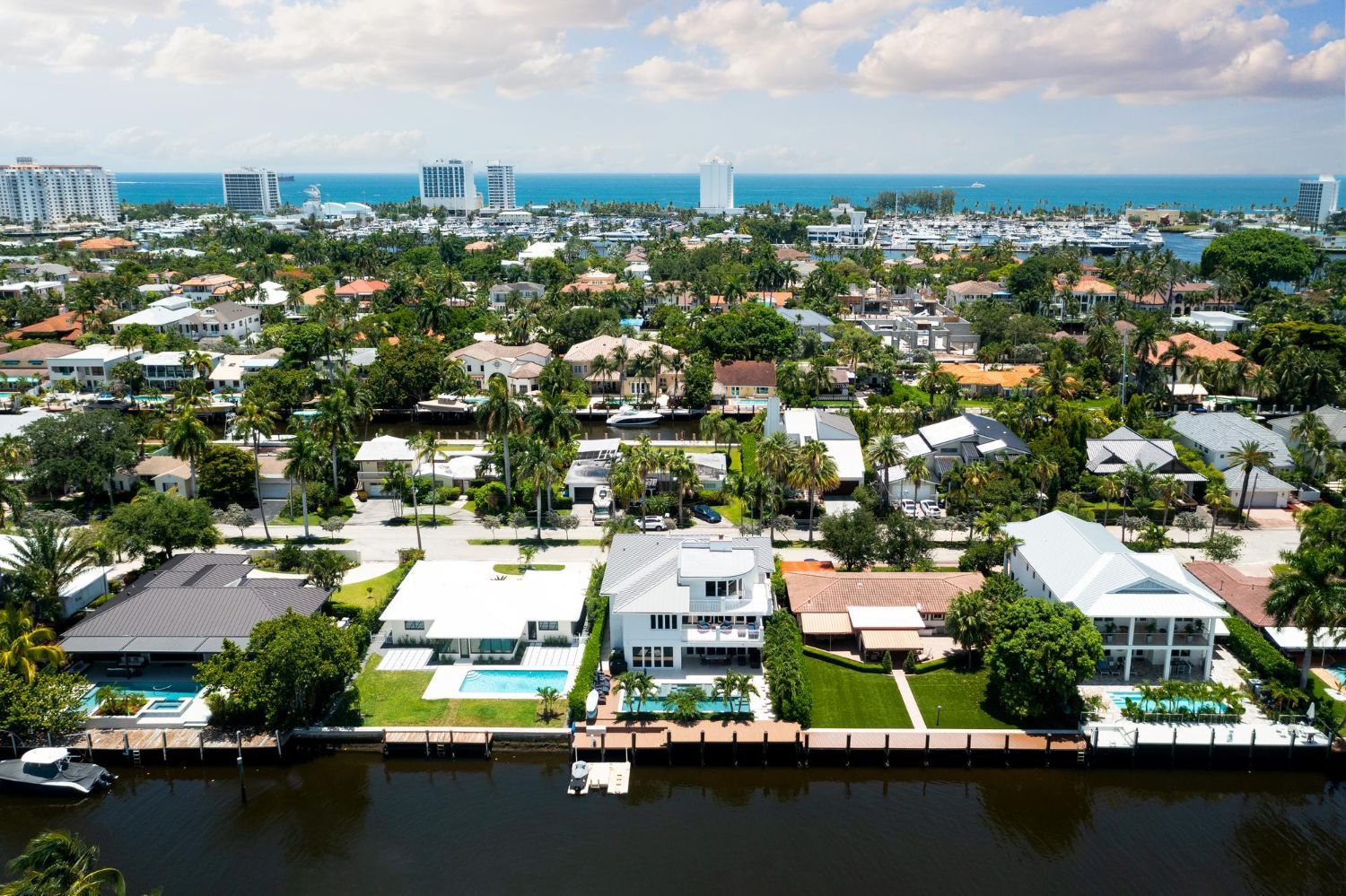 Aerial view of waterfront homes in a suburban neighborhood with ocean in the background.