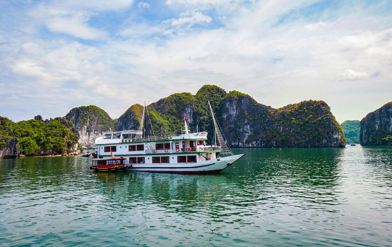 A boat is floating on top of a body of water with mountains in the background.