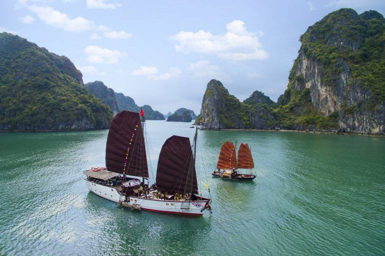 A group of sailboats are floating on top of a body of water.