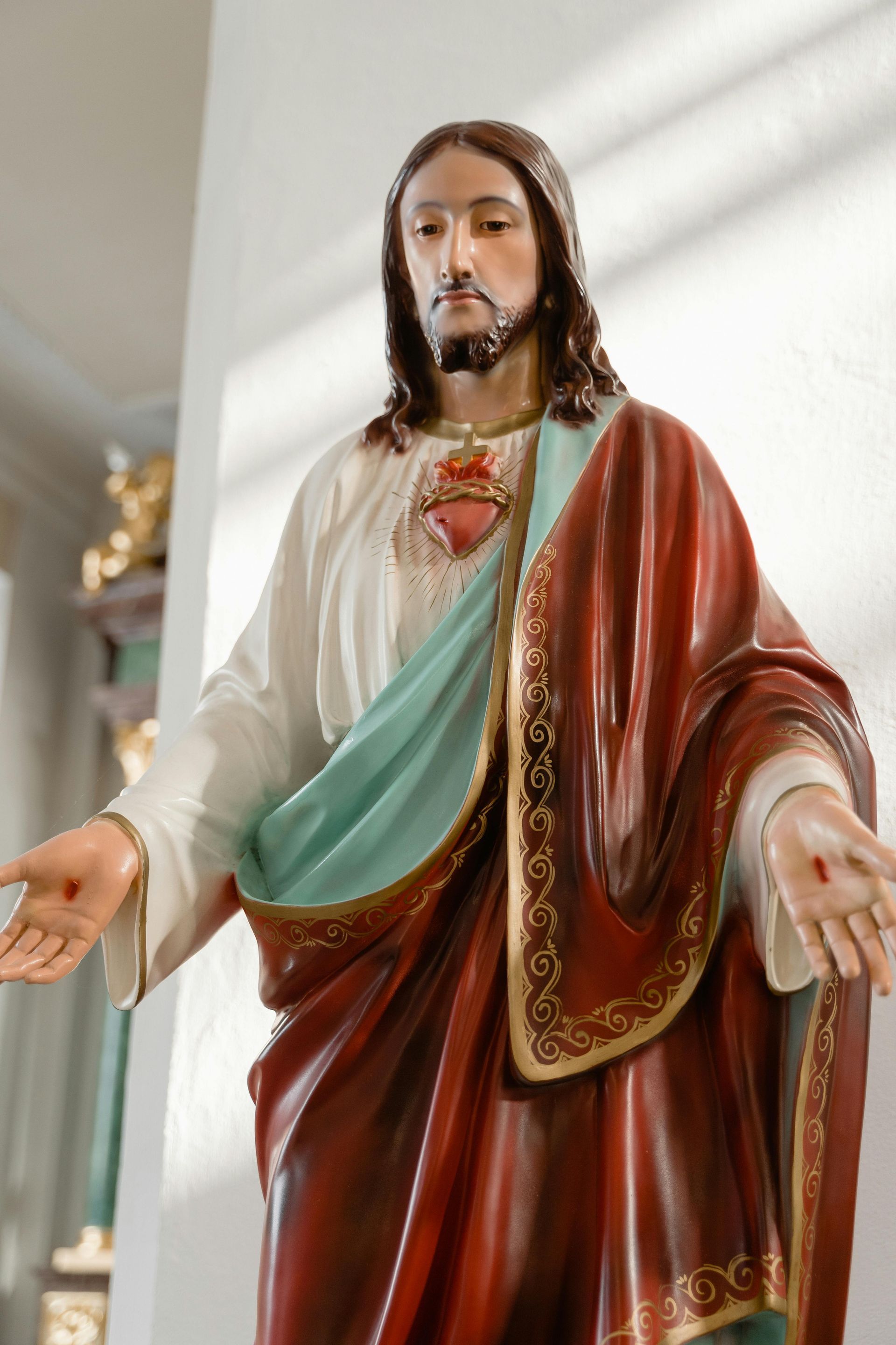 A close up of a statue of jesus with his arms outstretched
