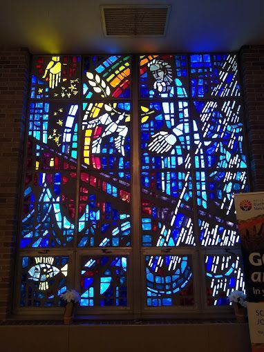 A stained glass window in a church with a religious scene on it.