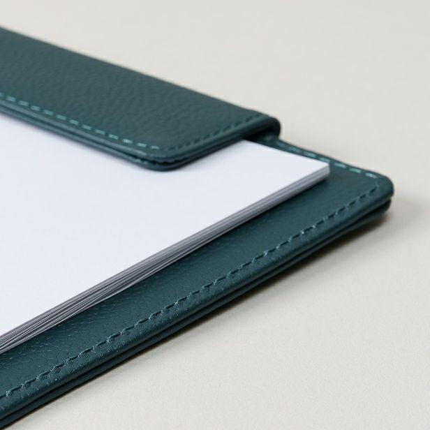 A teal leather document folio with precisely aligned white paper