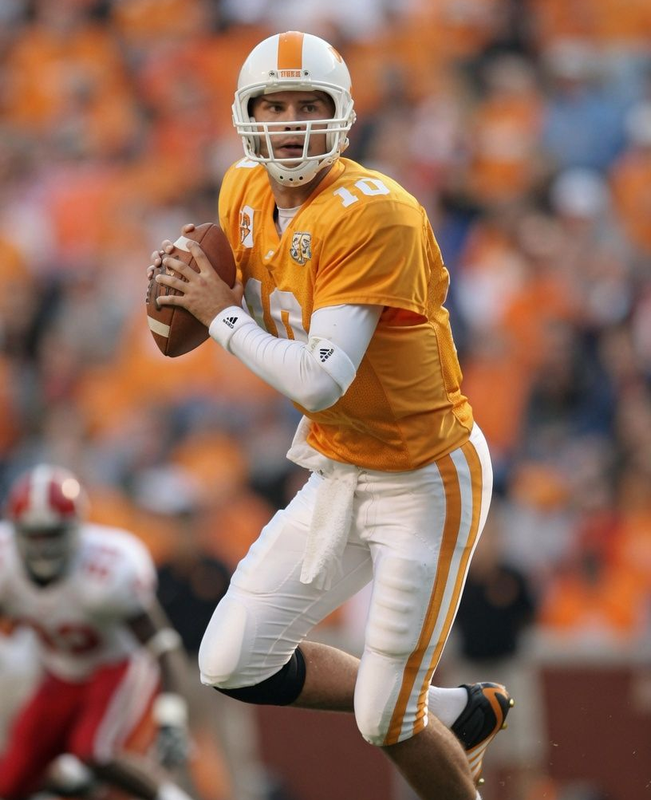 Tennessee Volunteers quarterback in orange jersey preparing to throw a football on the field