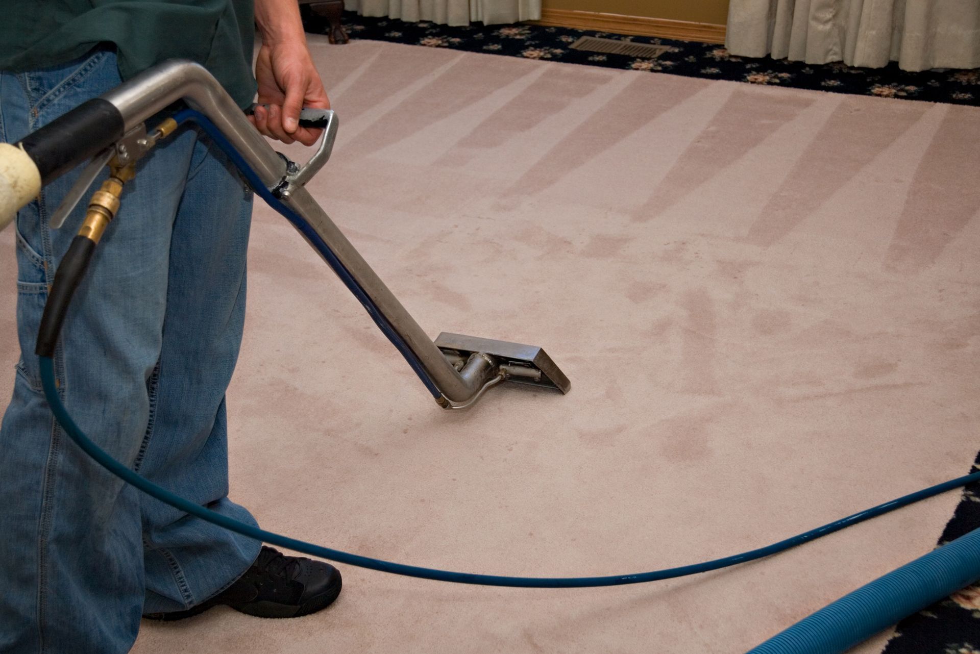 A man is cleaning a carpet with a vacuum cleaner. A man is cleaning a carpet with a vacuum cleaner.