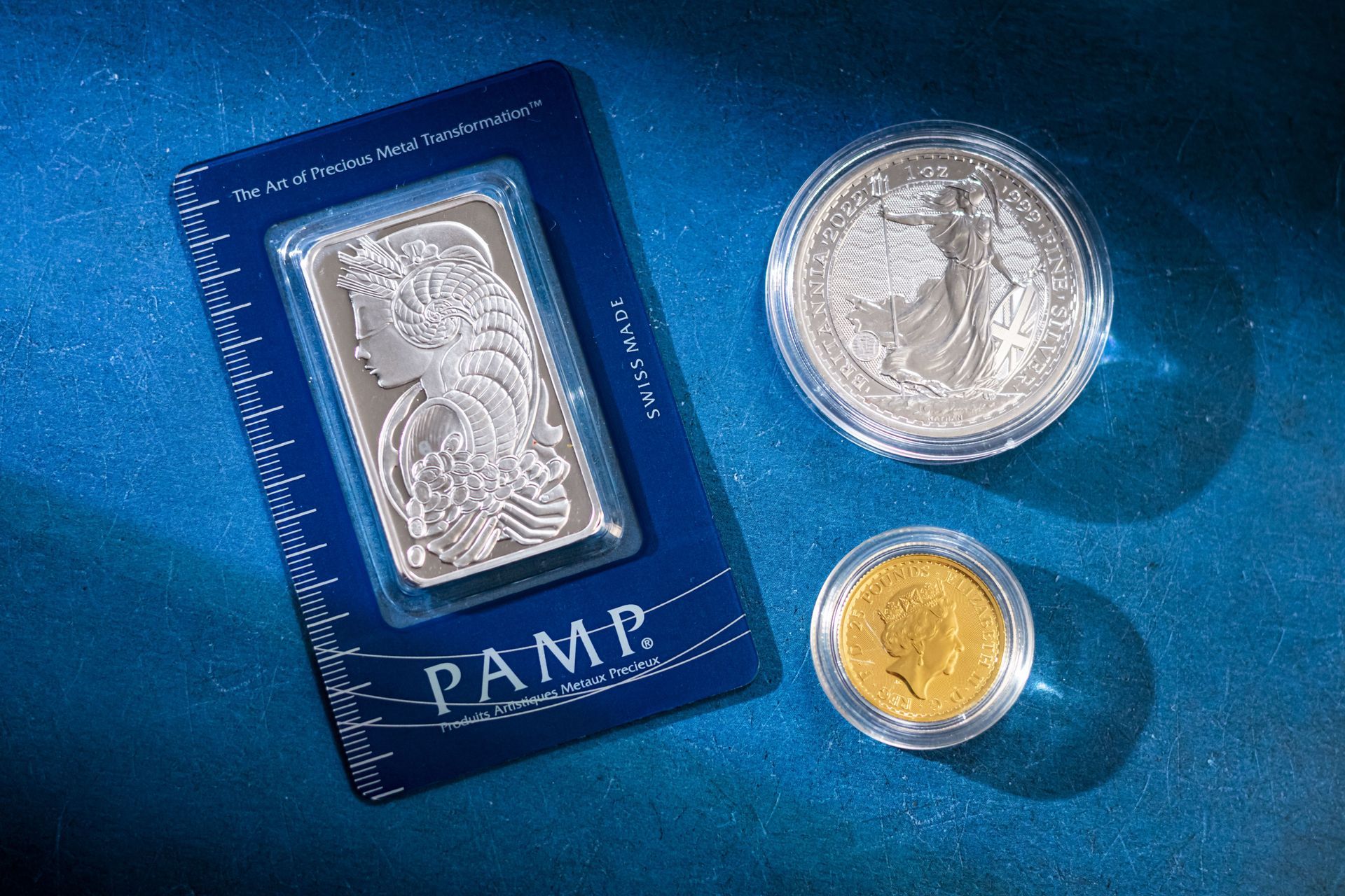 Gold coin being examined between two fingers against a dark background
