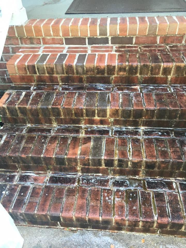 Weathered brick steps with dark stains and white streaks, viewed from the bottom up.