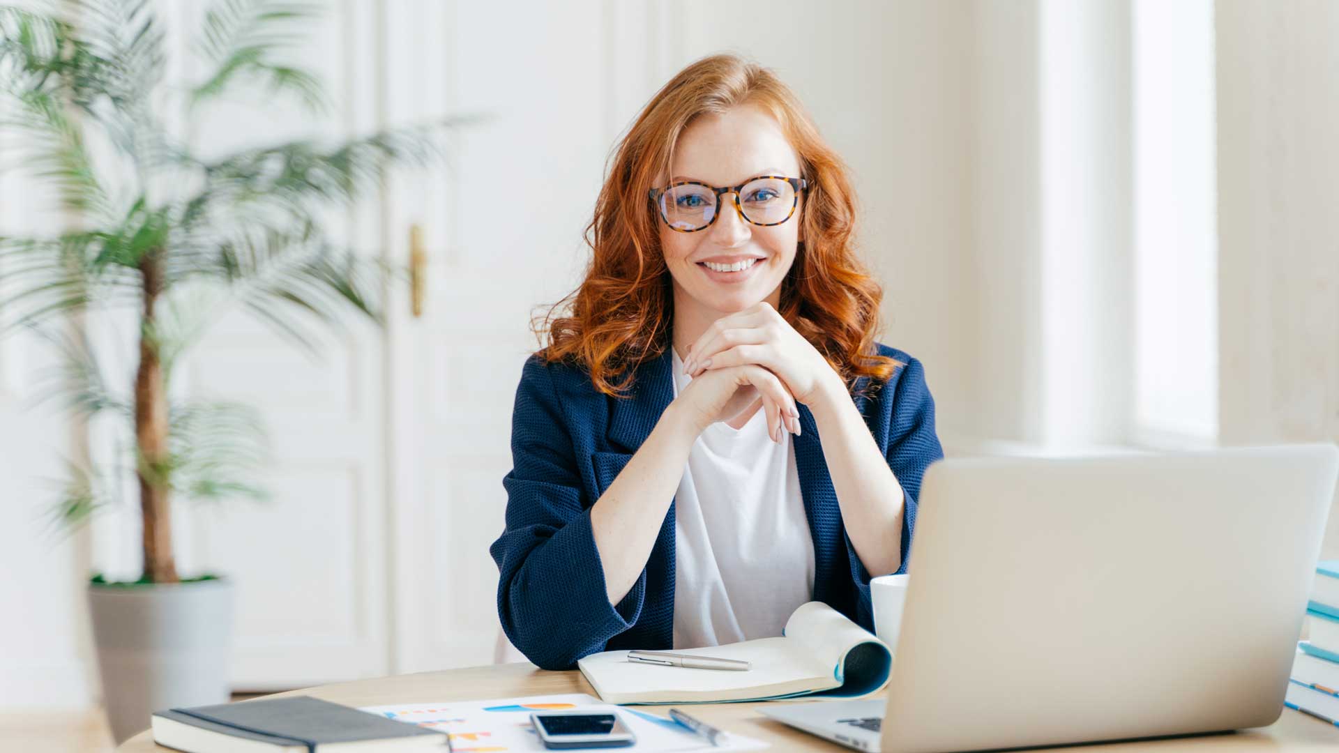 a woman is sitting at a desk in front of a laptop computer .