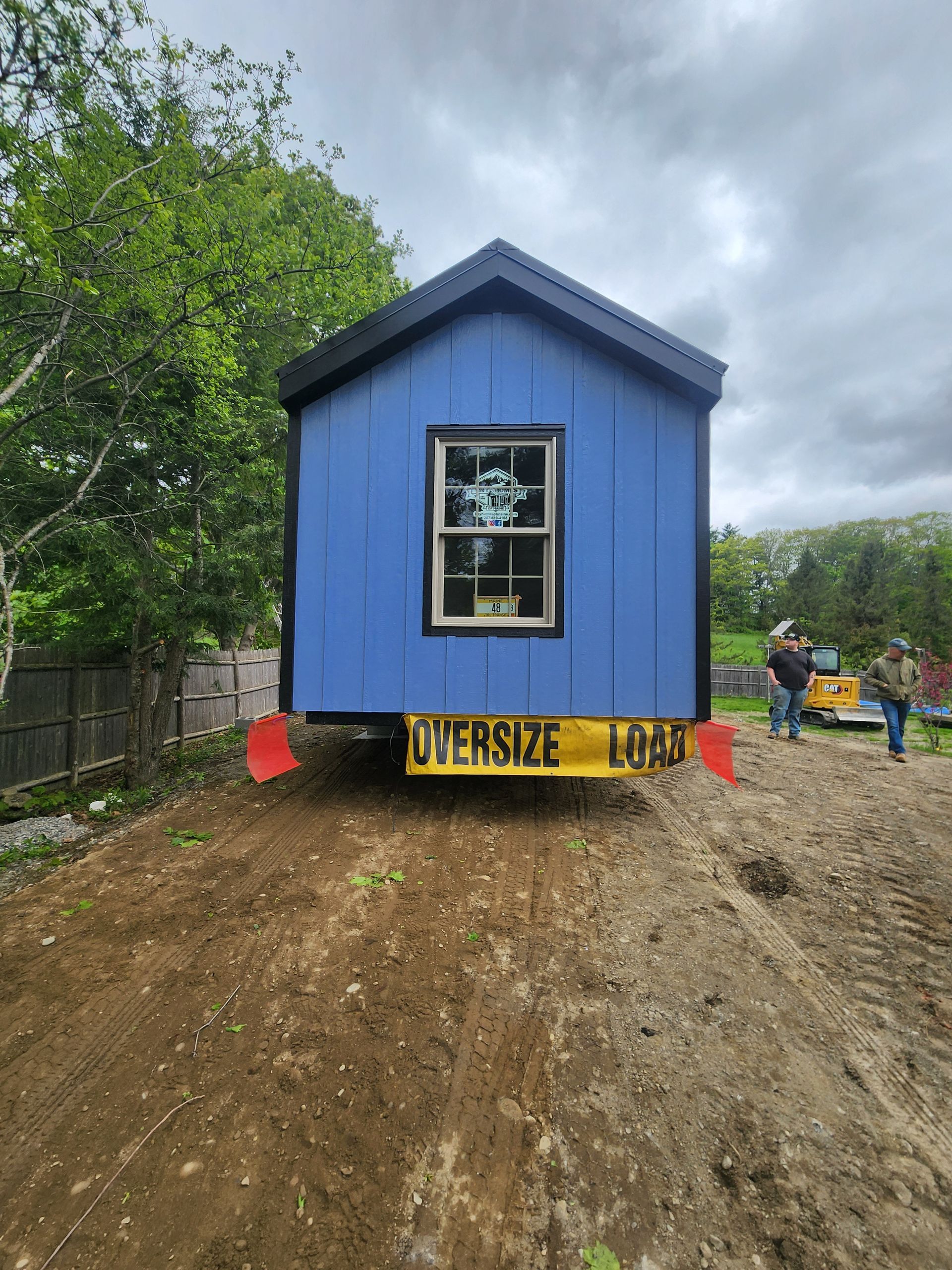 A blue tiny house on a trailer with an 