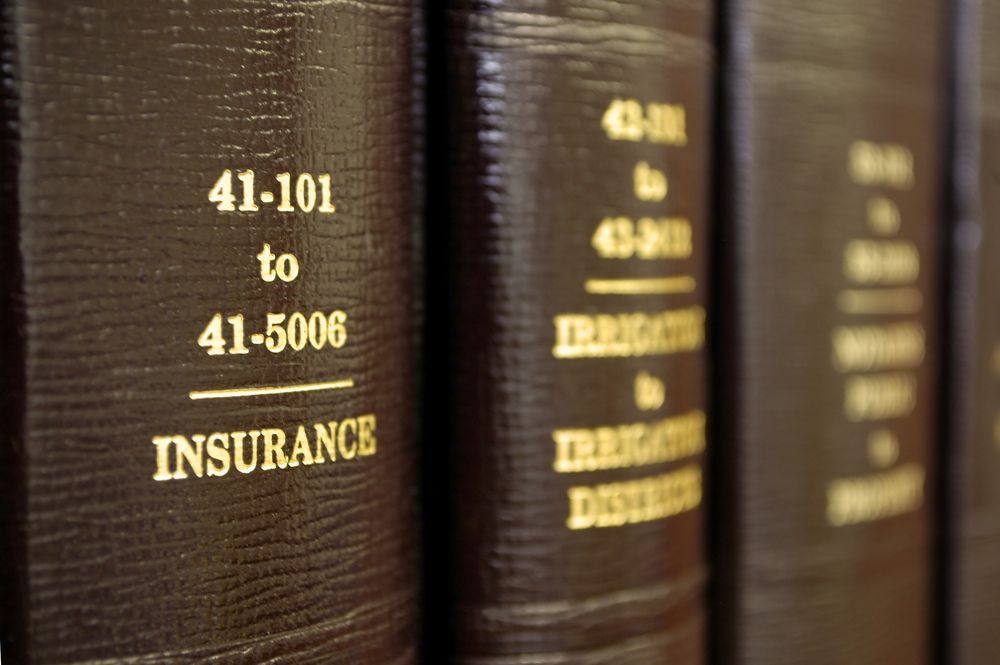 A Row Of Books On A Shelf One Of Which Is About Insurance — Bradley J Bragg - Solicitor in Atherton, QLD