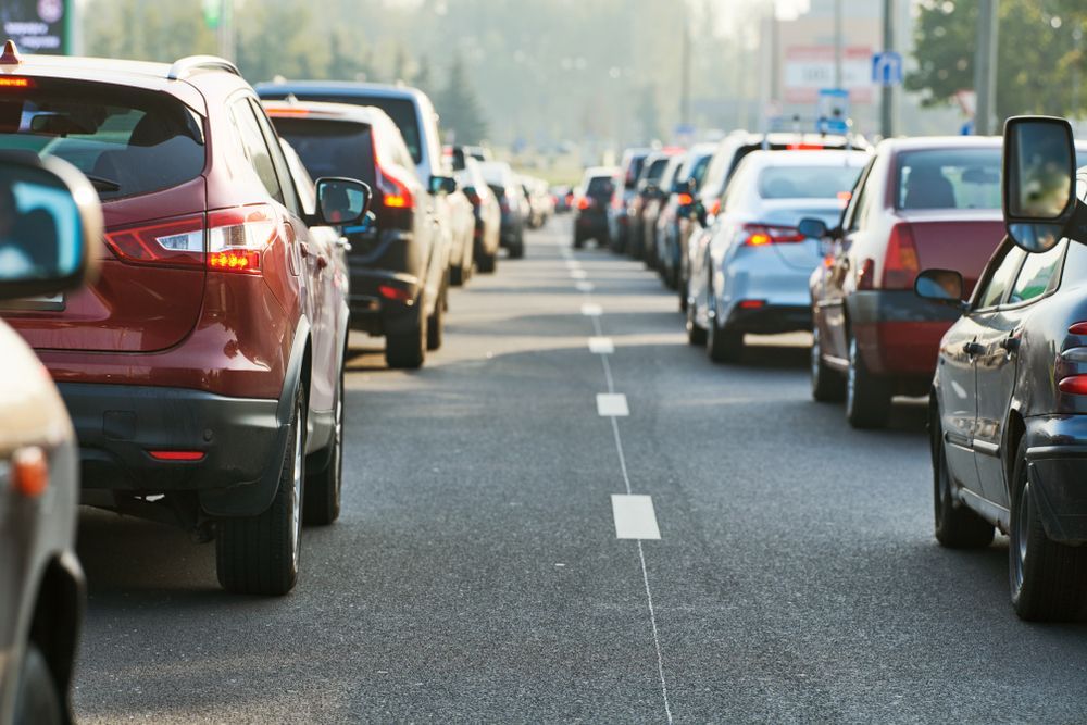 A Row Of Cars Are Driving Down A Busy City Street — Bradley J Bragg - Solicitor in Atherton, QLD