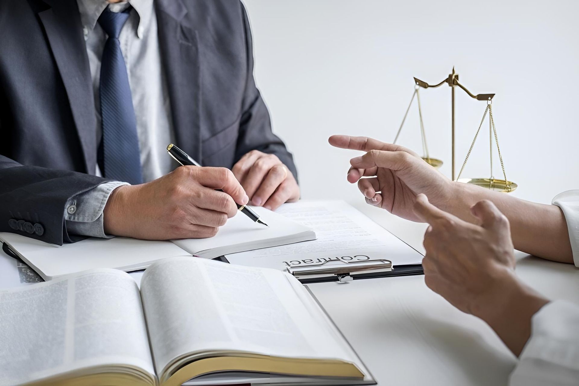 A Man in a Suit and Tie is Sitting at a Table Talking to a Woman — Bradley J Bragg - Solicitor in Cairns, QLD