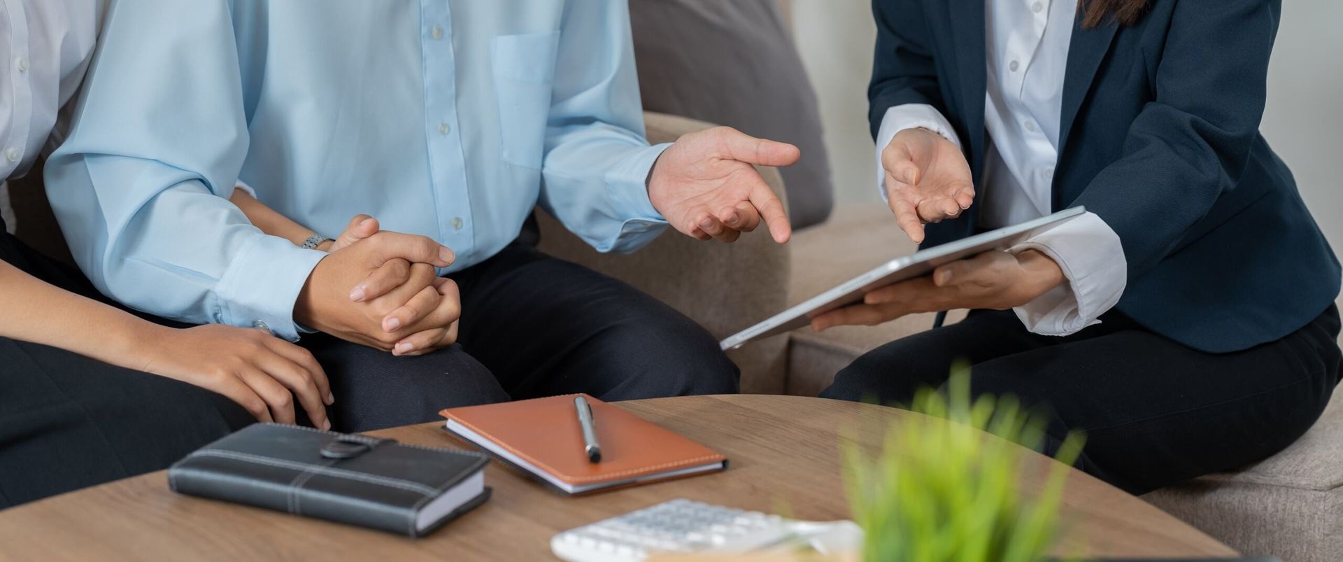 A Man and Woman Sitting at a Table With a Woman Holding a Tablet — Bradley J Bragg - Solicitor in Atherton, QLD