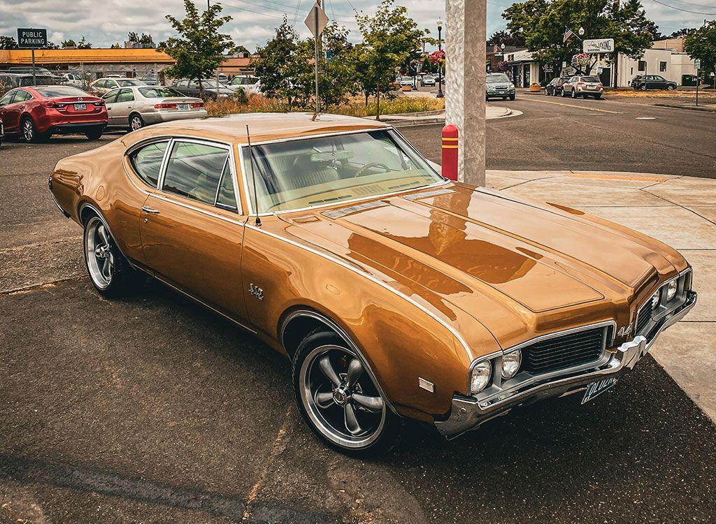 Golden vintage car parked on asphalt.