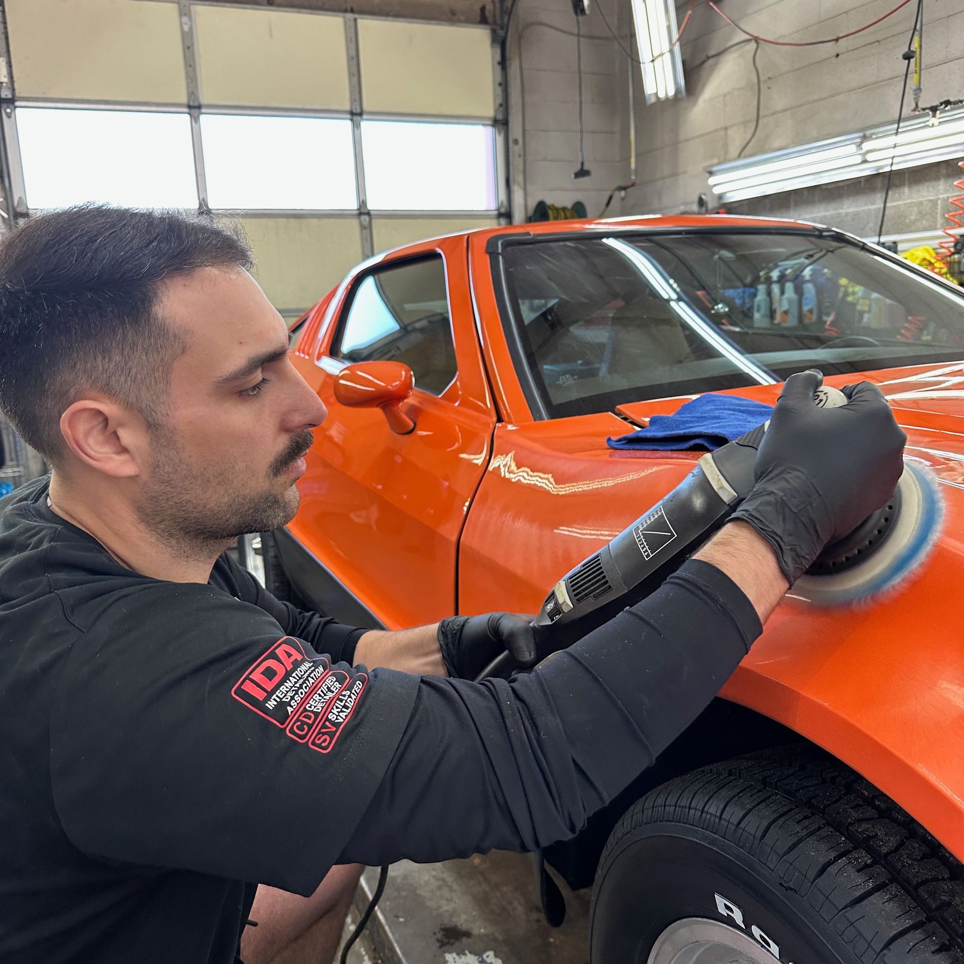 Certified detailing technician performing paint correction on a car prior to installing a pro-grade ceramic coating