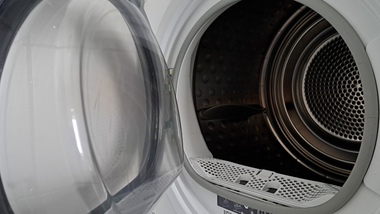 Open dryer door revealing the interior drum with a lint trap visible.
