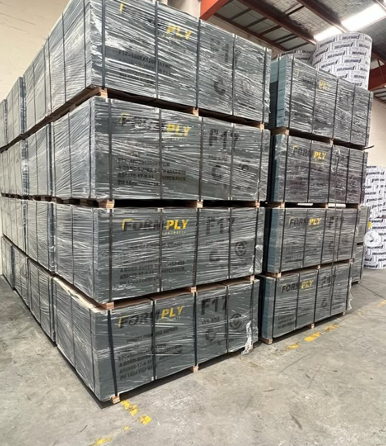 A warehouse filled with lots of boxes of plywood stacked on top of each other.