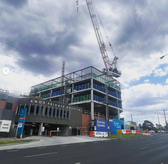 A large building under construction with a crane on top of it.