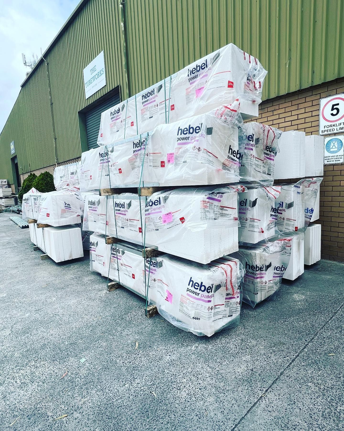 A large pile of styrofoam blocks stacked on each other in front of a building.