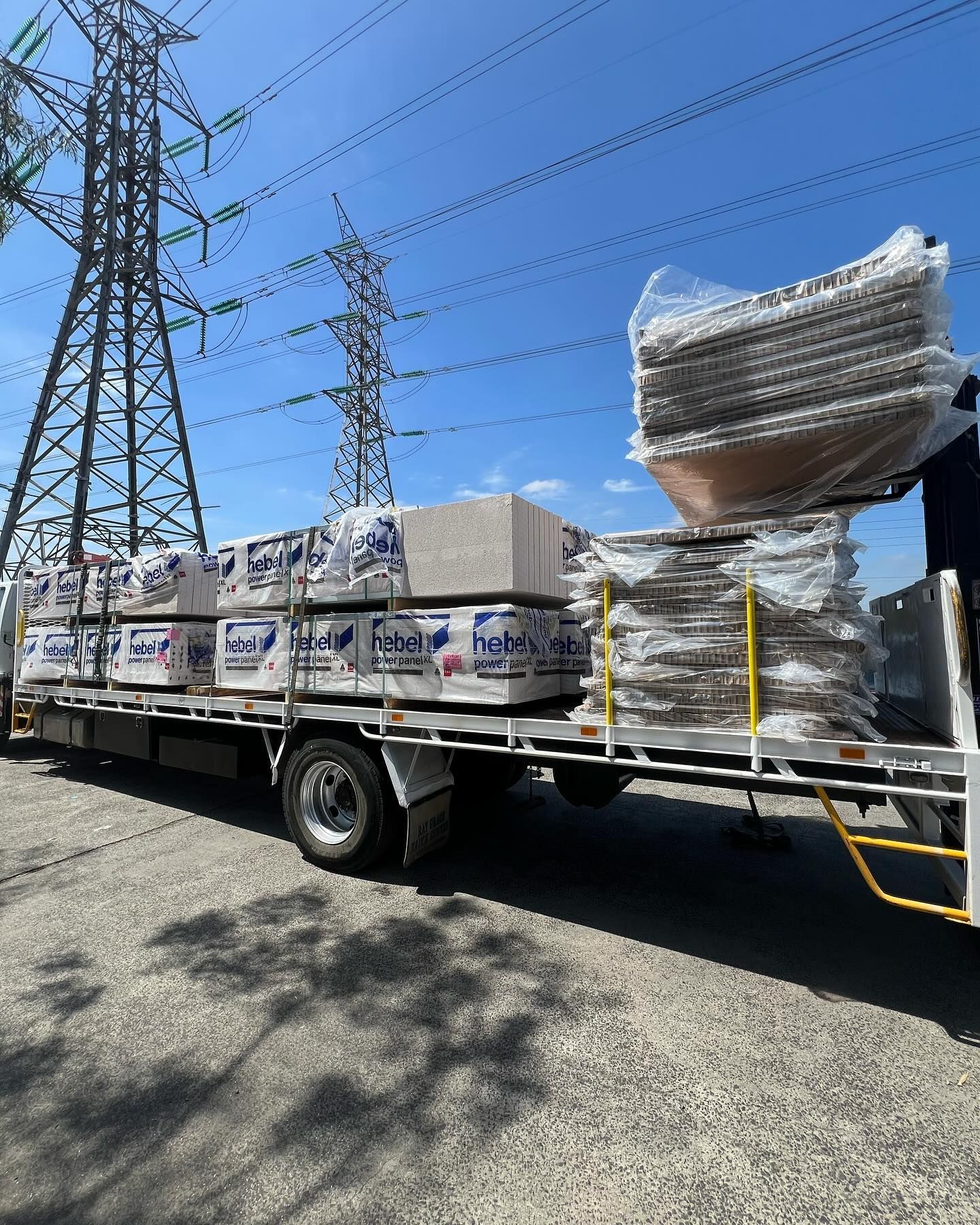 A truck is carrying a stack of bricks on the back of it.
