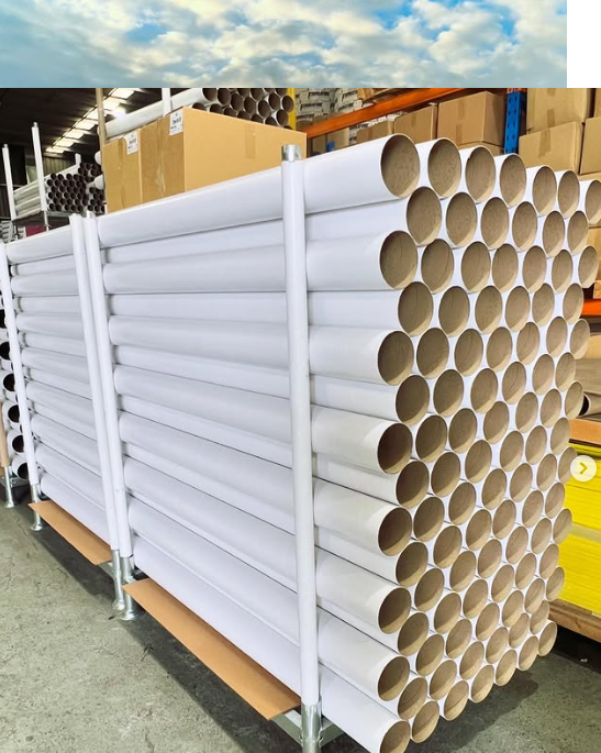 A large stack of cardboard tubes in a warehouse