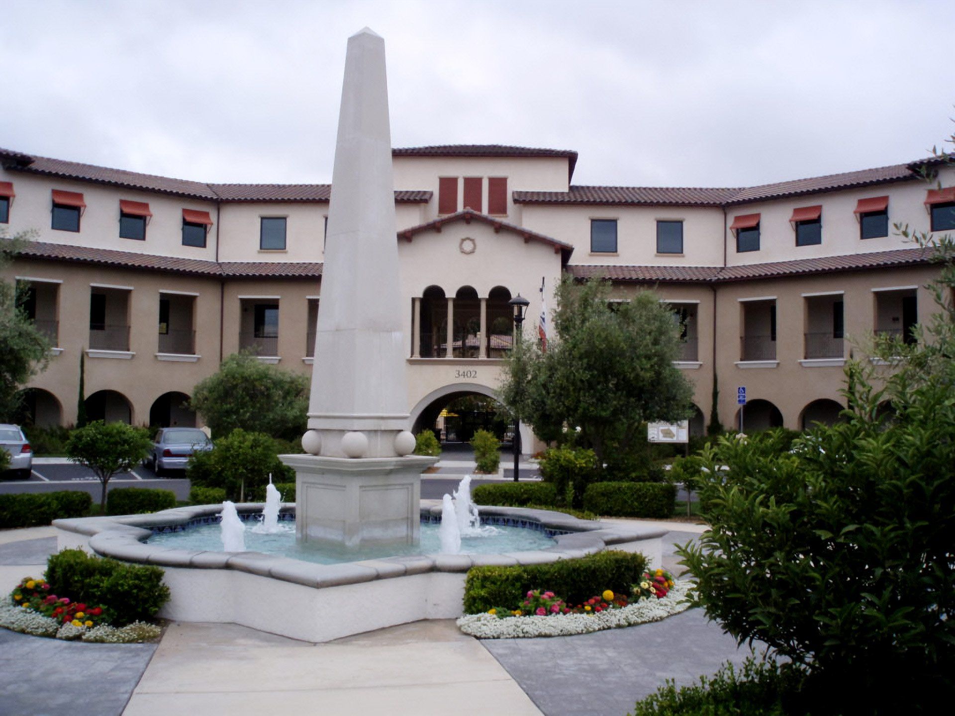 Courtyard fountain and obelisk in front of a Mediterranean-style building
