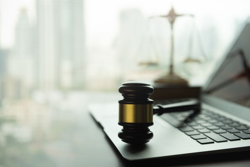 Gavel on Laptop Keyboard With Scales of Justice — Trapski Family Law Geelong in Newtown, VIC