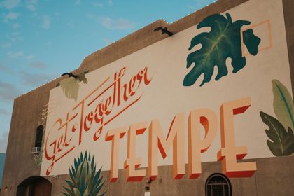 Tropical-themed temple mural with large red lettering on a cream wall