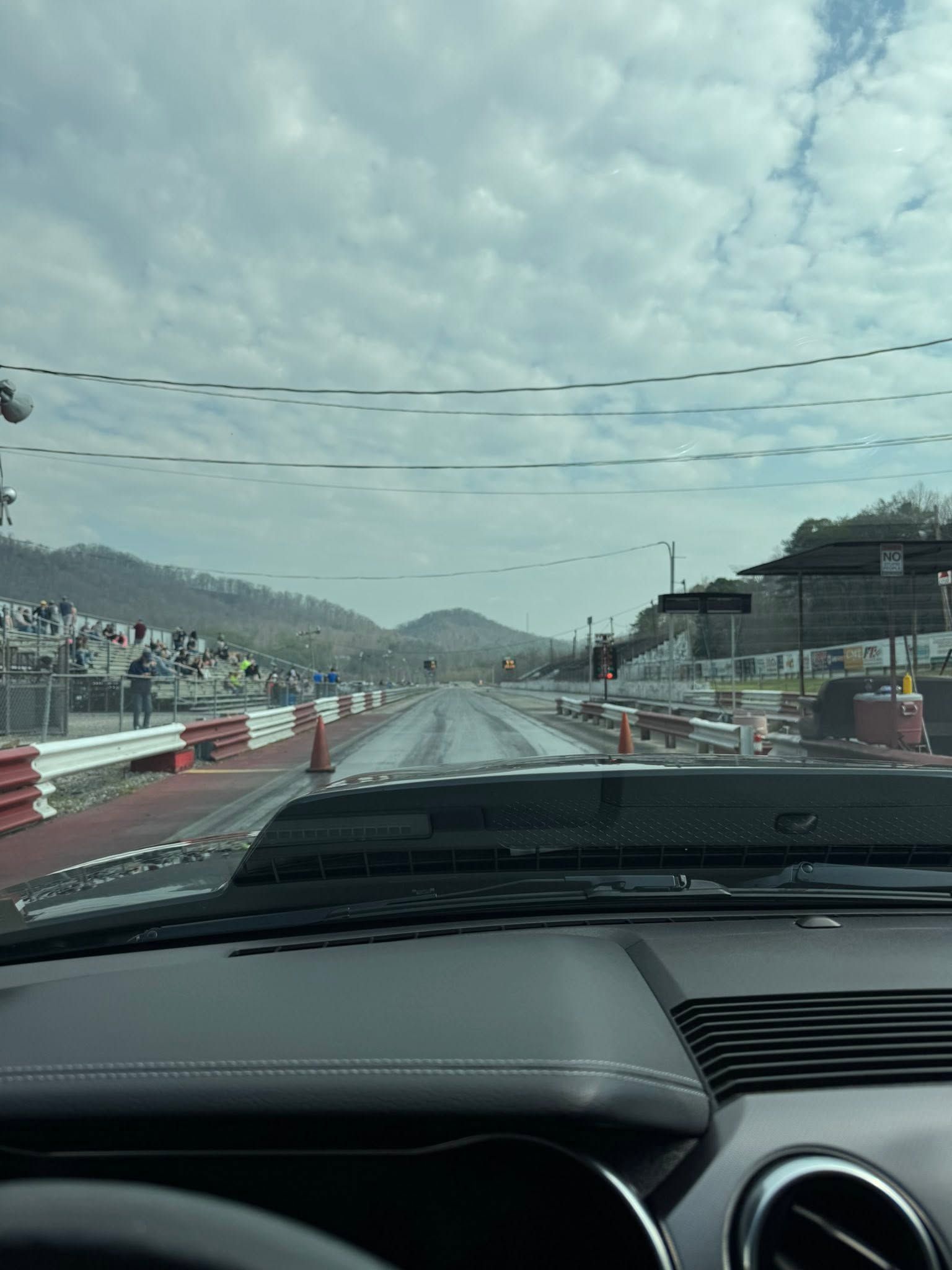 Driving on a wet bridge road under cloudy skies, seen from inside a car