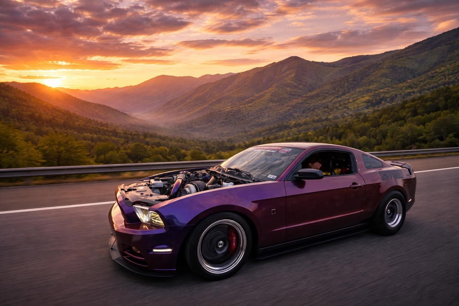 Purple sports car parked on a mountain road at sunset with a scenic valley backdrop