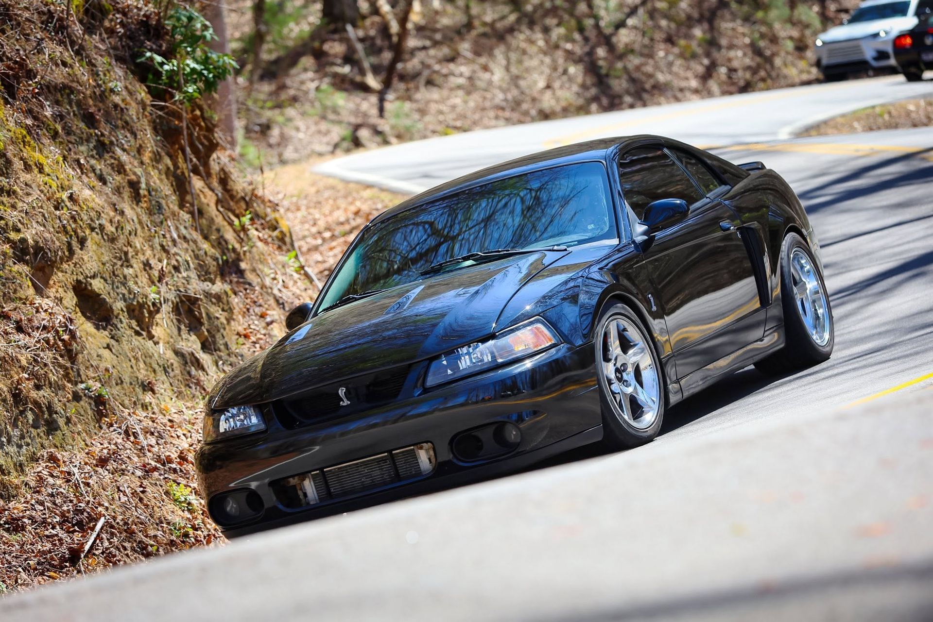 Black sports car driving on a winding mountain road