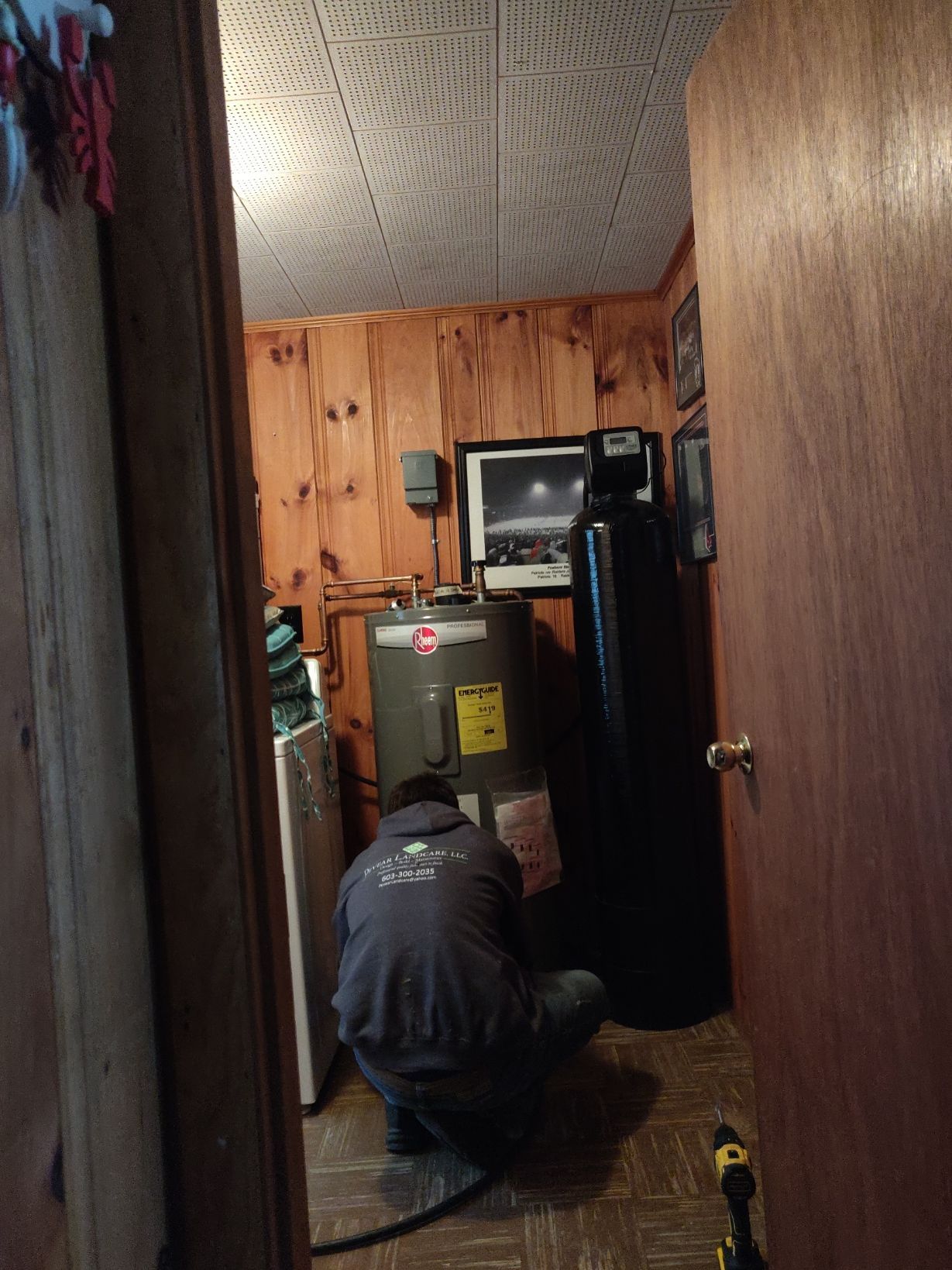 A man is working on a water heater in a room