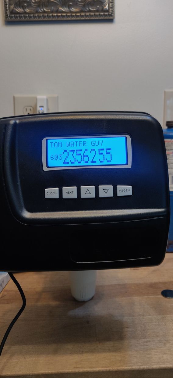 A water meter is sitting on a wooden table.