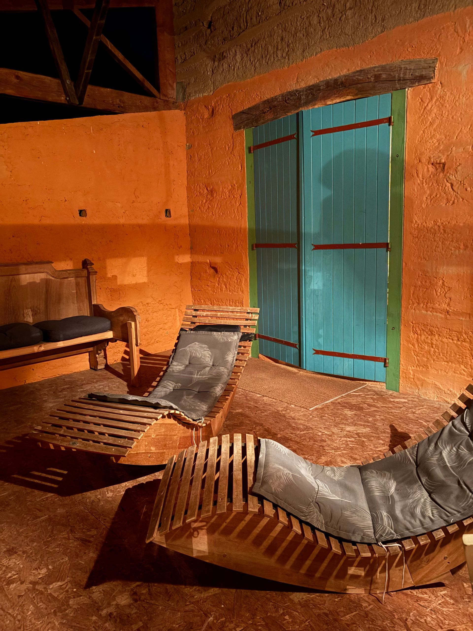 terrasse au couleur ressemblant aux maisons créoles, fauteuil en bois canapé 