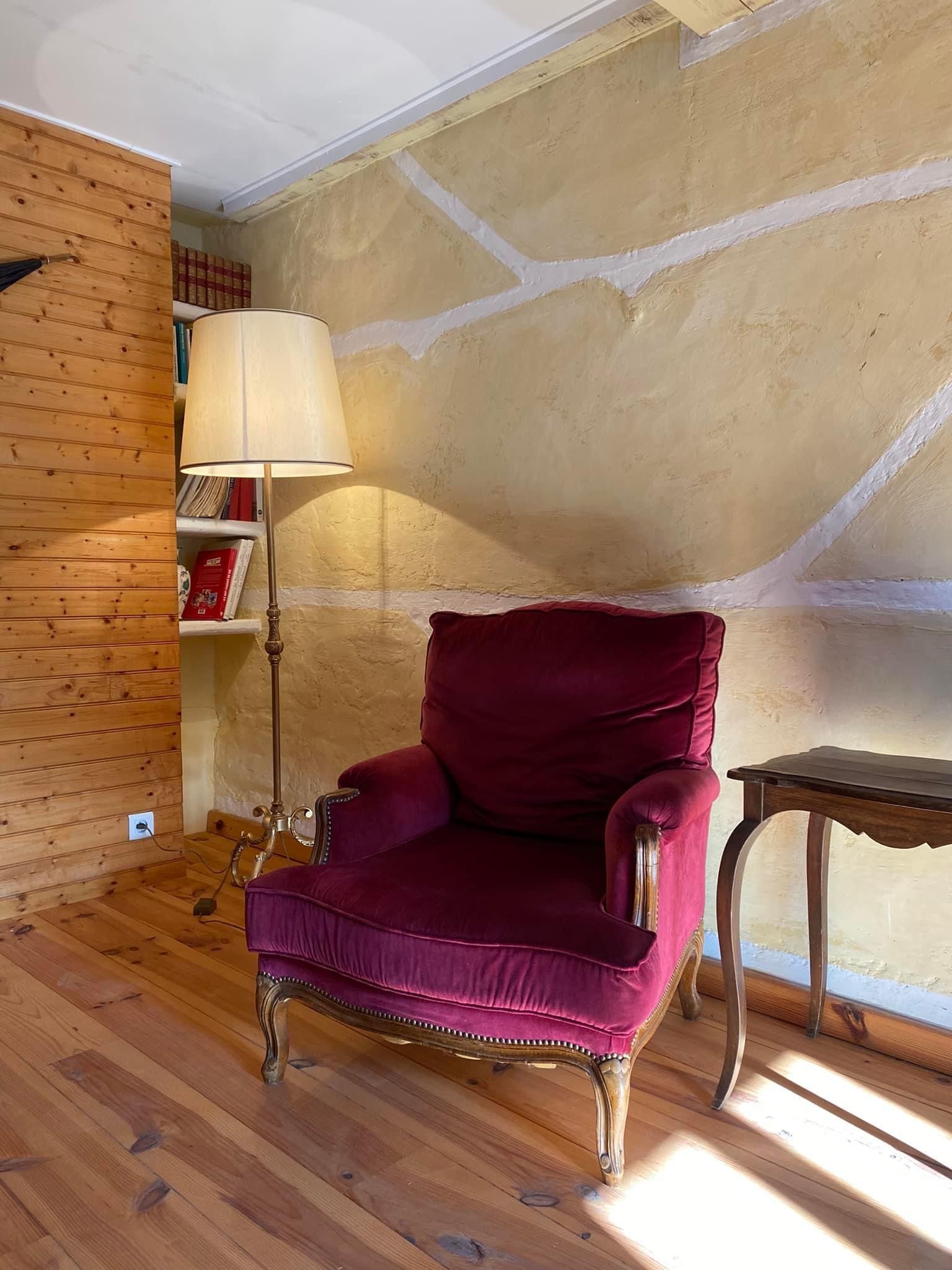 fauteuil rouge moelleux et lampe sur pied 