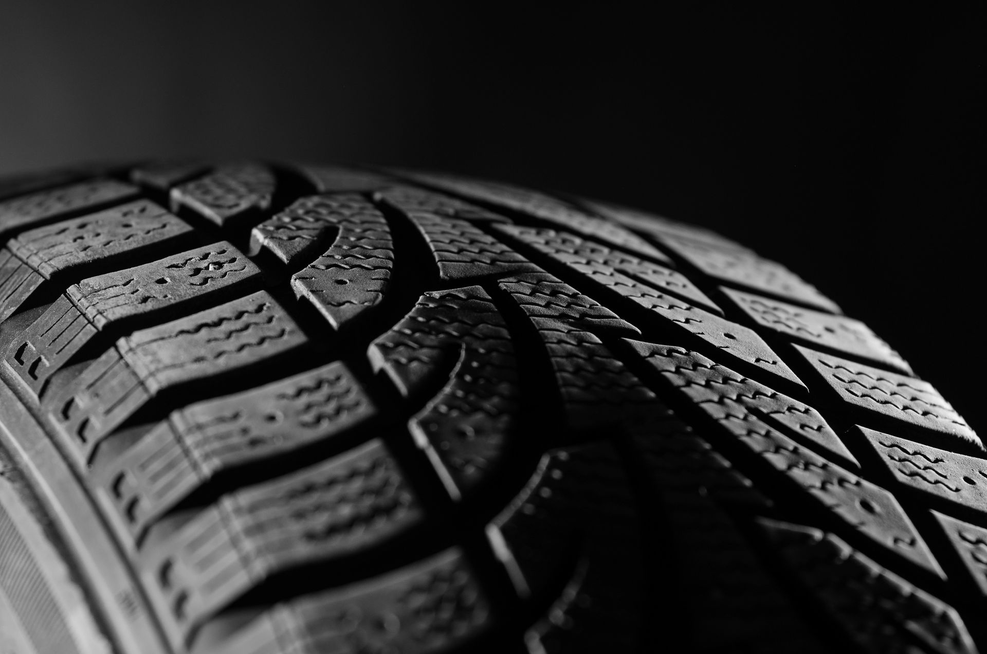 Primer plano en blanco y negro de la banda de rodadura de un neumático de coche