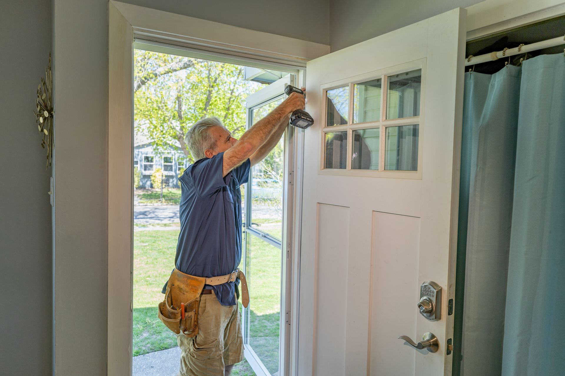 A man is installing a door in a house.