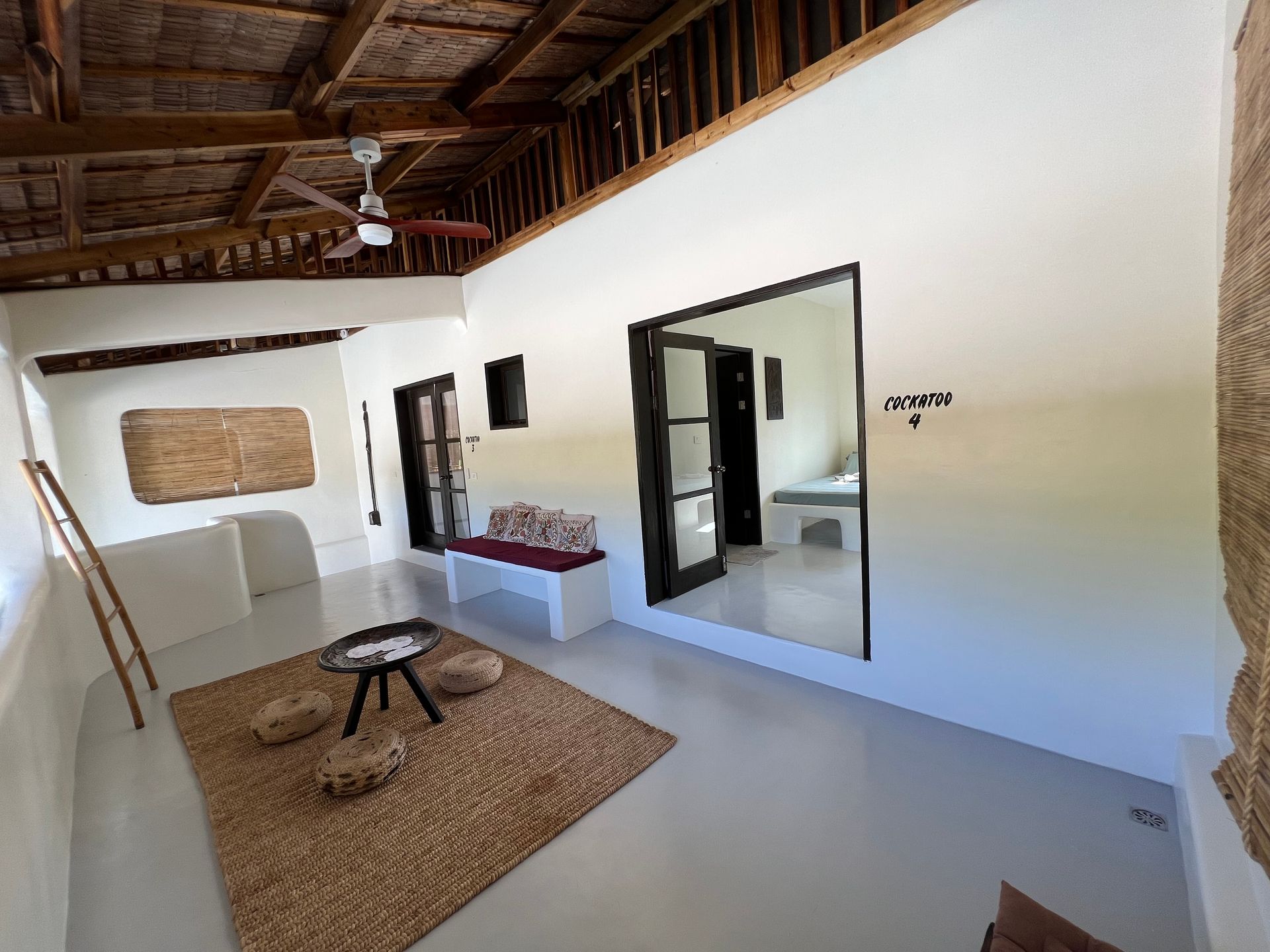 A living room with white walls and a ceiling fan