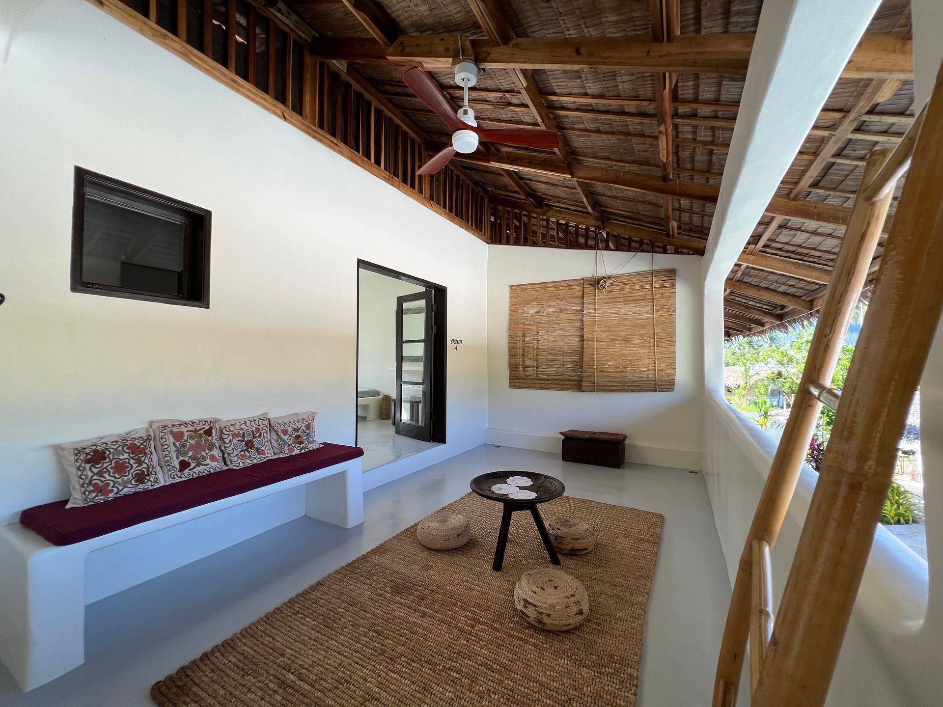 A living room with a bench and a ceiling fan
