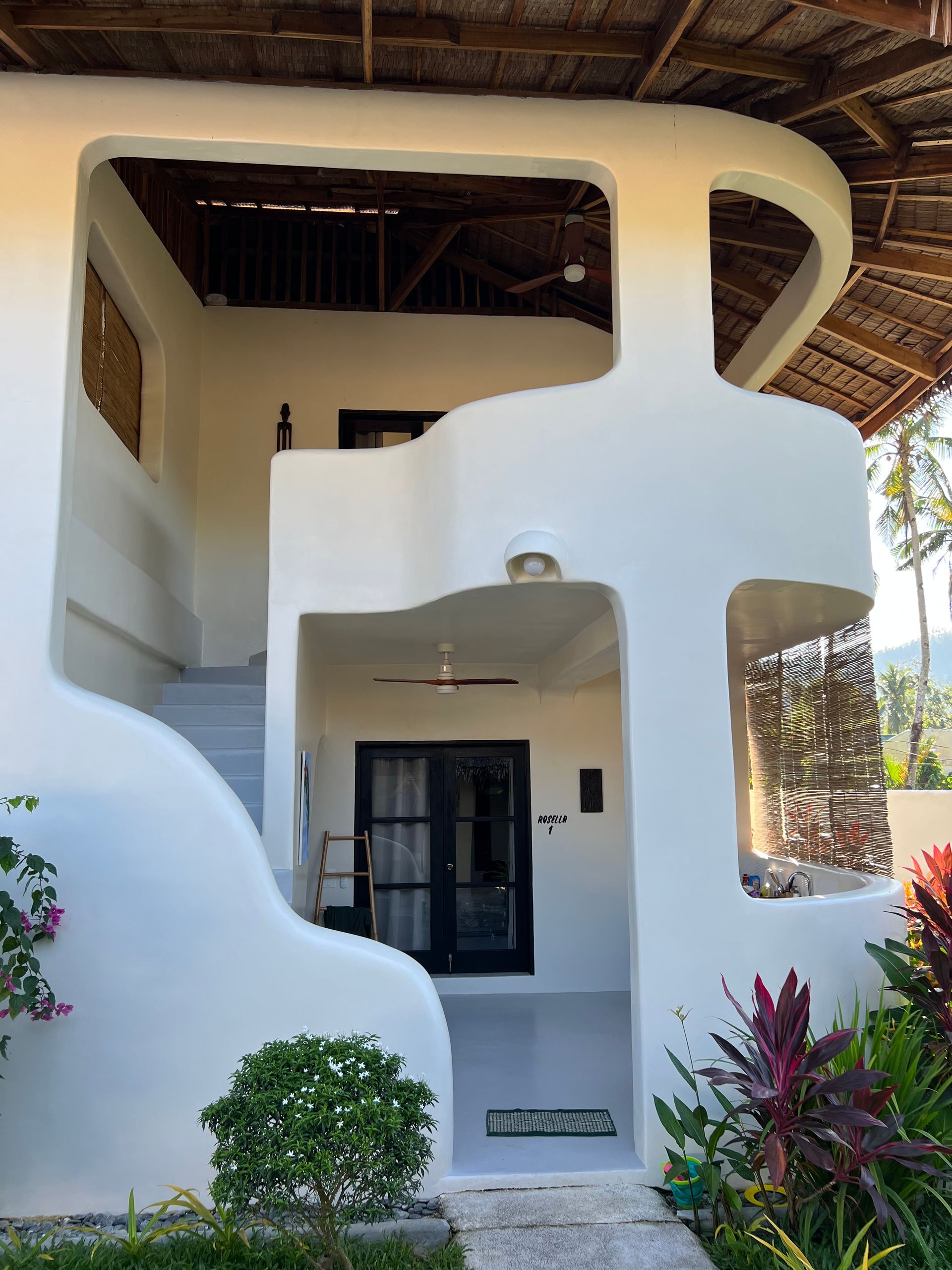 A white house with stairs leading up to the second floor