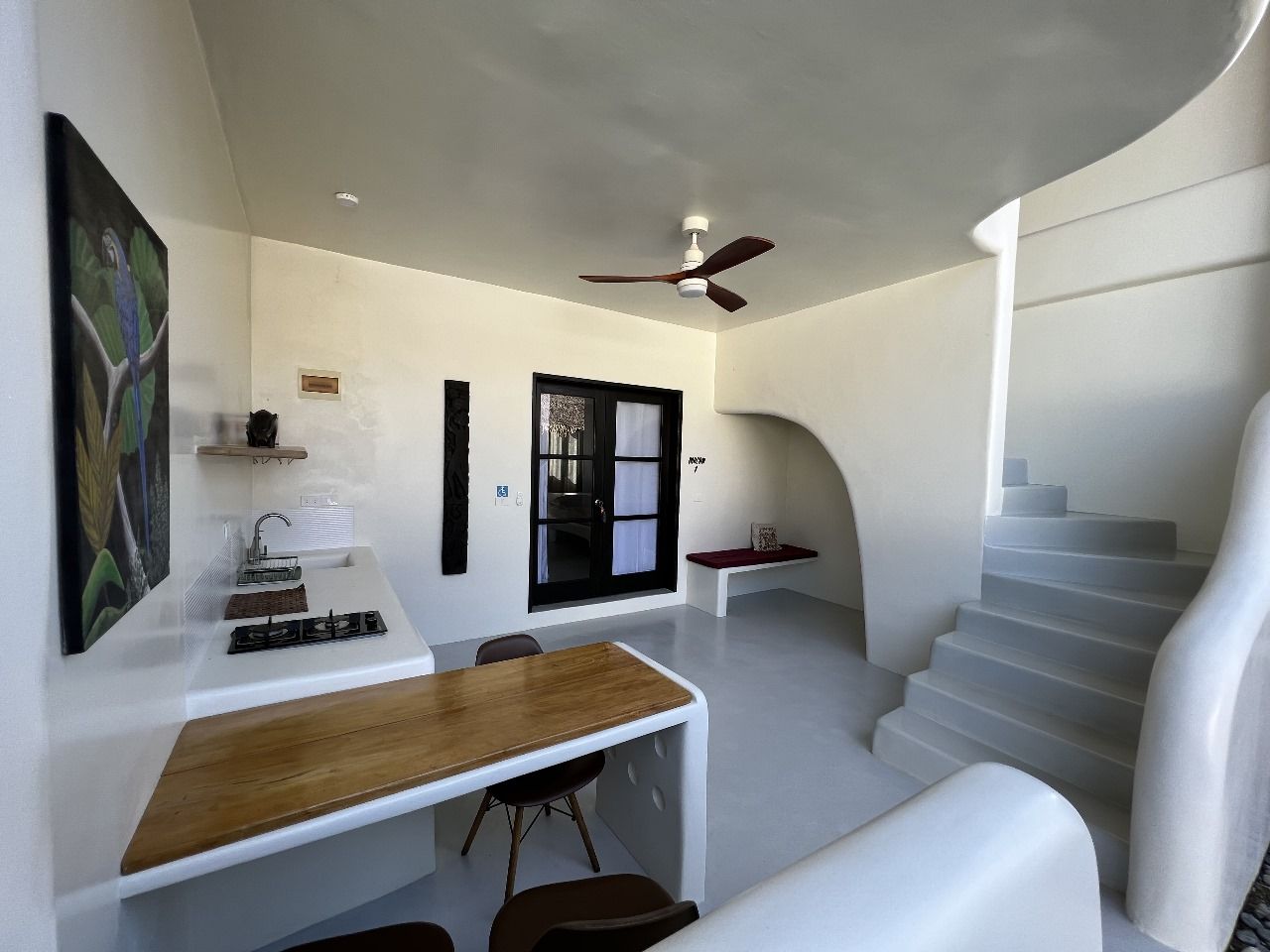 A kitchen with a table and chairs and a ceiling fan