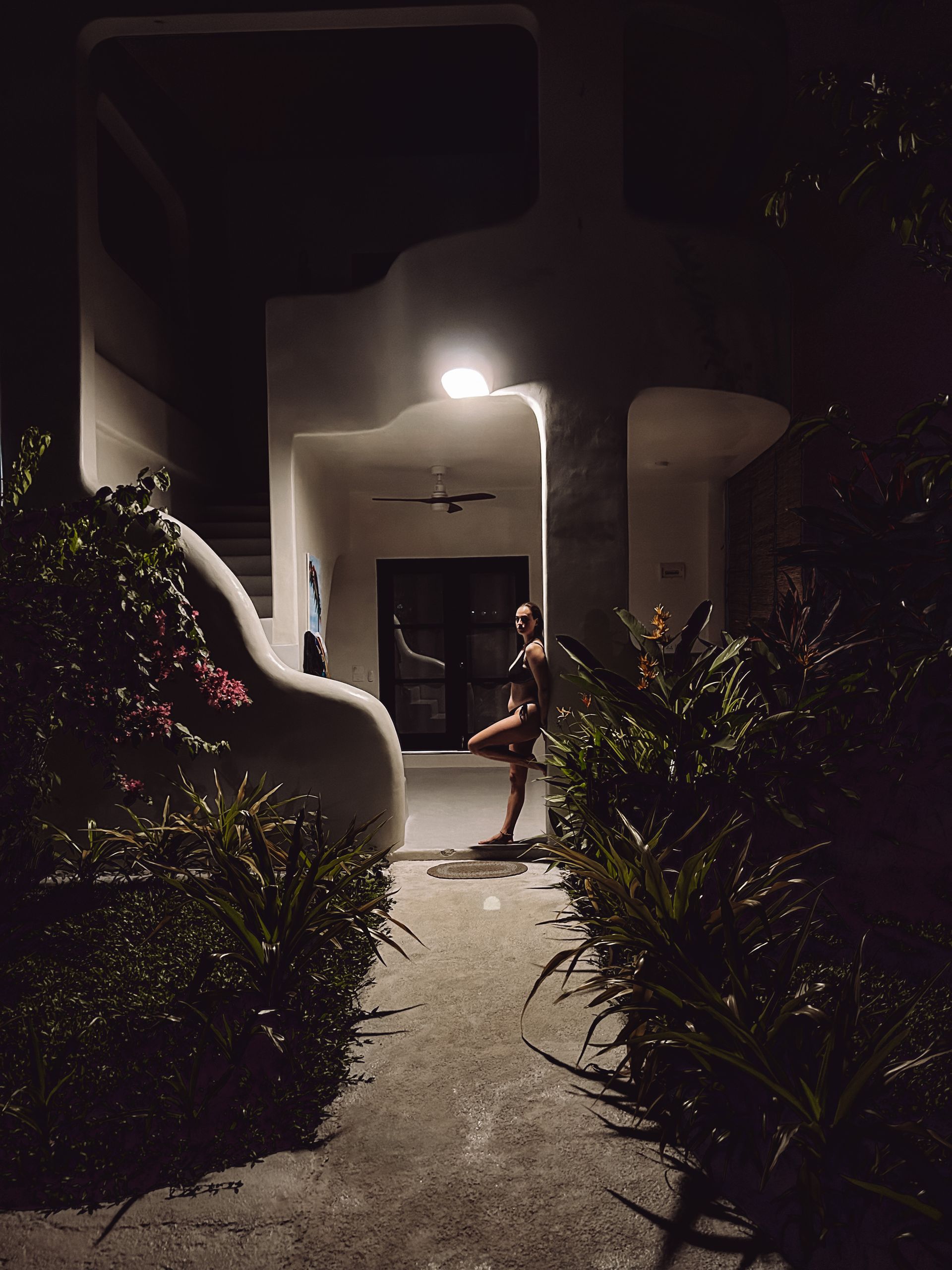 A person standing in front of a building at night