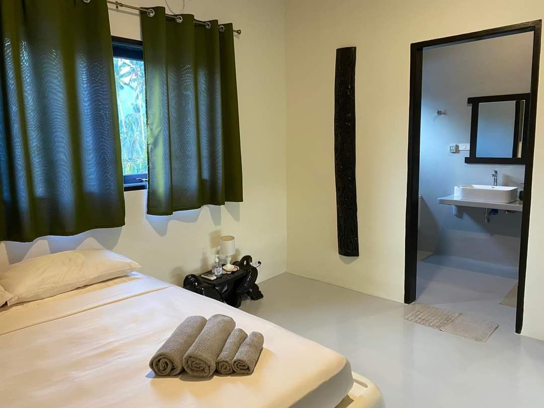 A bedroom with a bed and a bathroom with a sink.