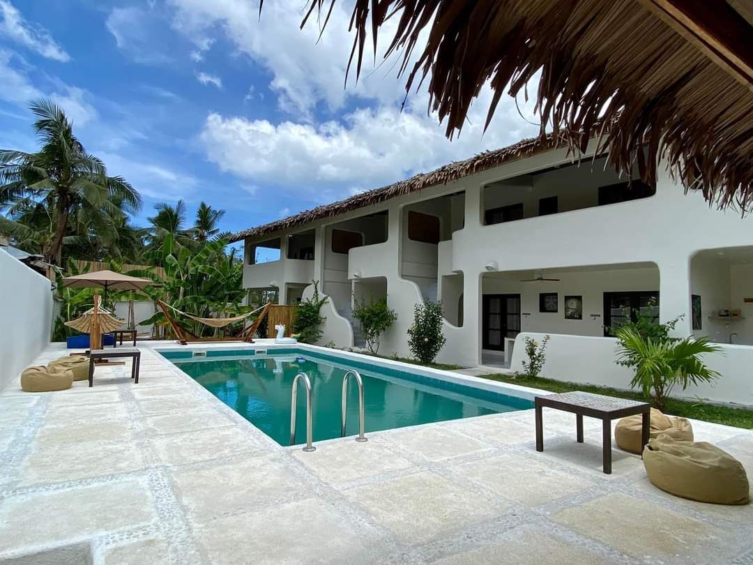 A large swimming pool in front of a white building