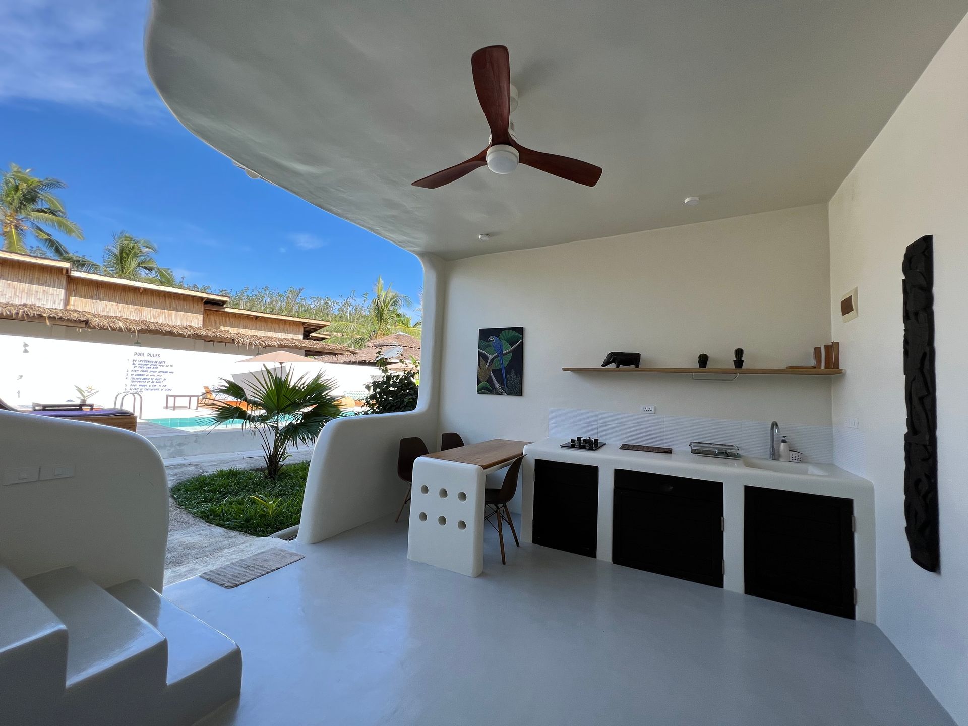 A kitchen with a ceiling fan and stairs leading to it