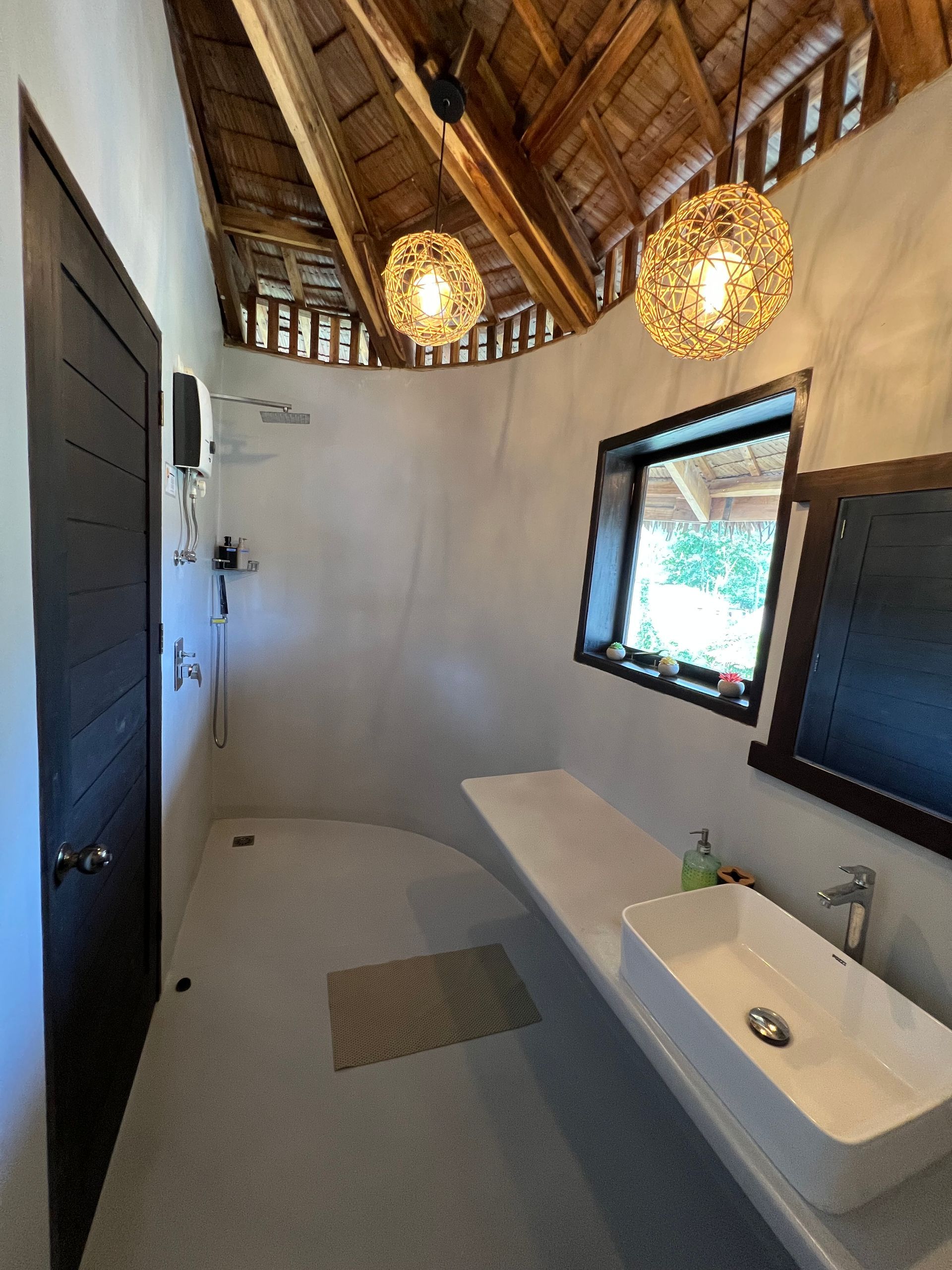 A bathroom with a sink , shower and window