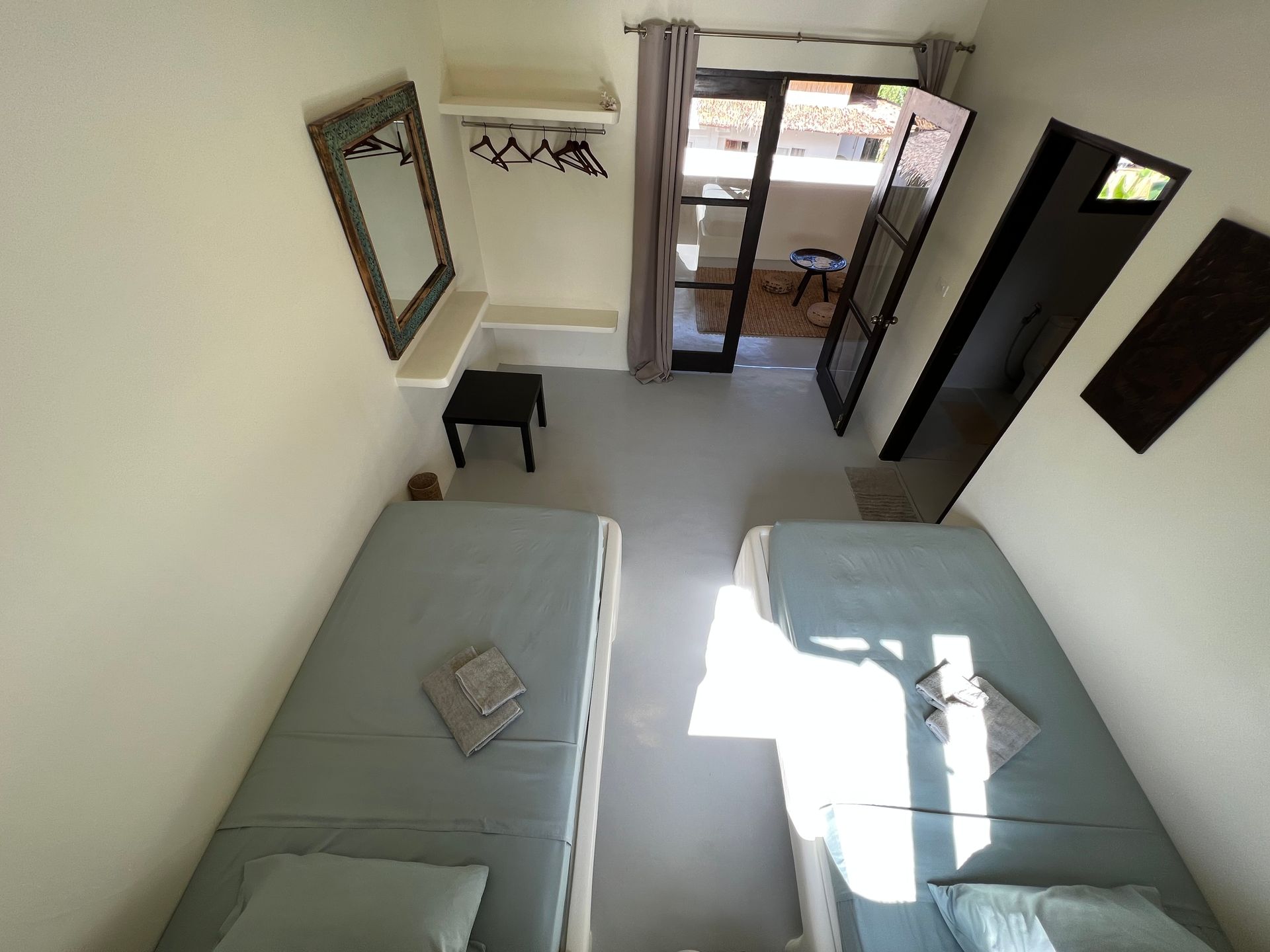 An aerial view of a bedroom with two beds and a mirror