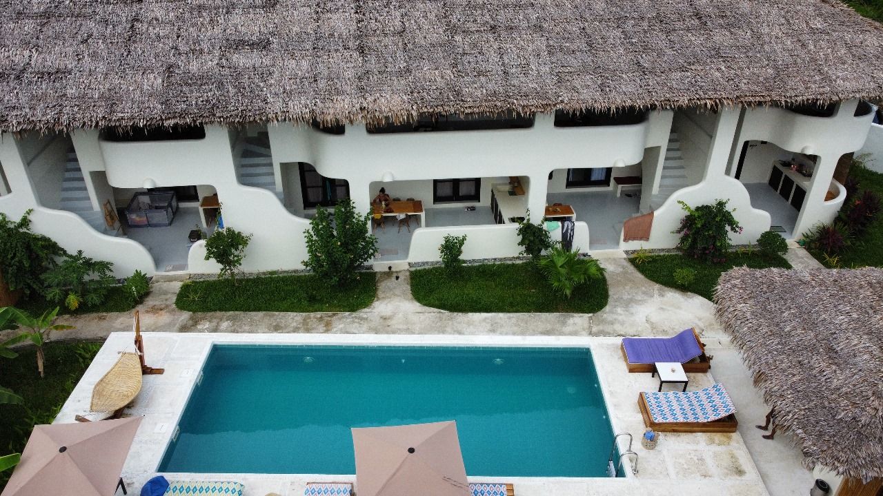 An aerial view of a hotel with a large swimming pool